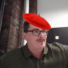 a man wearing glasses and a red beret on top of his head