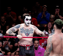 a man in a wrestling ring has a tattoo on his chest that says bat