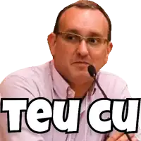 a man wearing glasses is speaking into a microphone with the words teu cu written above him