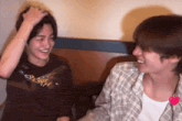 two young men are laughing and one has a shirt on that says ' almost ' on it