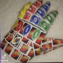 a hand made out of uno cards on a carpet .