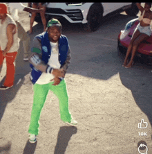 a man wearing green pants and a blue jacket is dancing