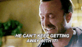 a man is smiling with the words he can 't keep getting away with it behind him