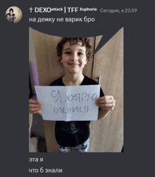 a young boy is holding a sign that says ca xyapyo