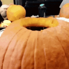 a person is carving a large pumpkin with a hole in the middle .