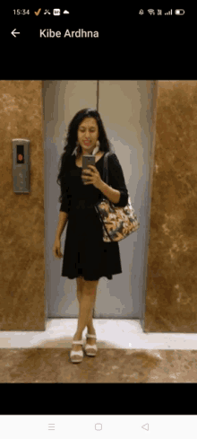 a woman taking a picture of herself in an elevator with the name kibe ardhna