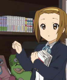 a girl in a school uniform is holding a stack of books in front of a shelf full of books