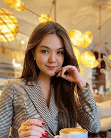 a woman in a plaid jacket holds a cup of coffee