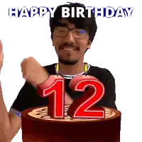 a man celebrates his 12th birthday by blowing out candles on a cake