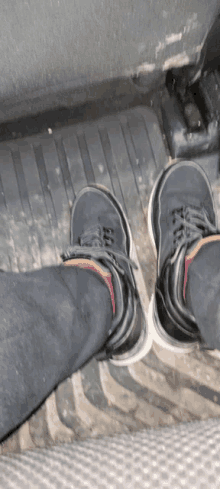 a person 's feet are shown with a pair of black shoes