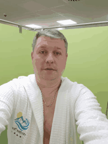 a man taking a selfie with a white robe that says ' leningrad ' on it