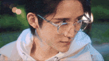 a close up of a person wearing glasses and a hoodie