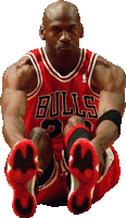 a basketball player wearing a bulls jersey sits on the floor