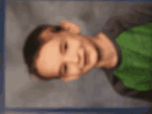 a blurry photo of a young boy wearing a green shirt