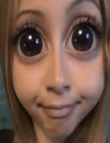 a close up of a woman 's face with big eyes making a cartoon face .
