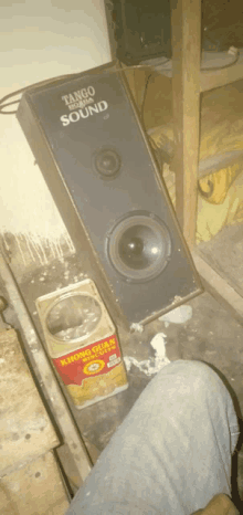 a tango sound speaker sits on a dirty floor