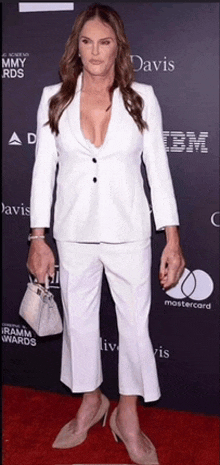 a woman in a white suit is standing on a red carpet in front of ibm