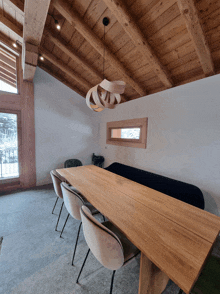 a dining room with a wooden table and chairs and a window