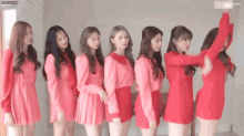 a group of girls in red dresses are standing in a line