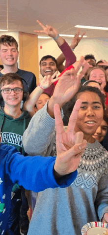 a group of young people are posing for a picture with one wearing a green hoodie that says gebro