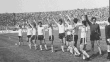 a group of soccer players are raising their hands in the air