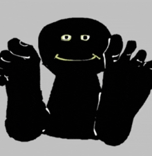 a black cartoon character with a smiley face and yellow eyes .