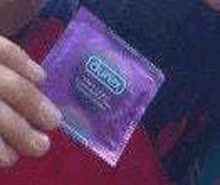 a close up of a person holding a purple condom .