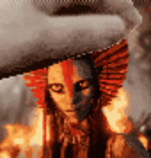 a close up of a woman 's face with a feathered hat on .