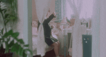 a girl sits on a bed in a room with a canopy