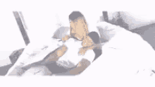 a man and a woman are laying on a bed together .