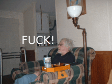 an elderly man sits in a chair with a tray on his arm and the word fuck written above him