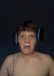 a shirtless man wearing headphones making a funny face .