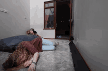 a woman is laying on the floor in a room with a door open