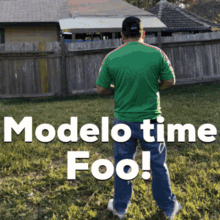 a man in a green shirt stands in front of a wooden fence with the words modelo time foo above him