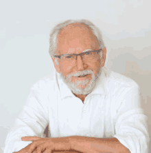 an older man with glasses and a beard is wearing a white shirt