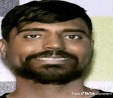 a man with a beard and mustache is smiling .