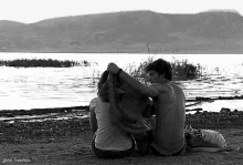 a black and white photo of a man and a woman sitting on a beach with the words great-freedom below them