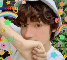 a boy wearing a white hat with a rainbow and the word wormy written on it