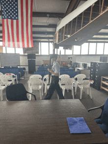 an american flag hangs from the ceiling above a row of white chairs