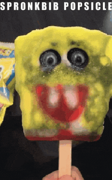 a person is holding a popsicle that looks like a spongebob character