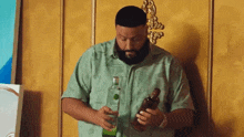 a man with a beard is holding a bottle of alcohol and a glass of alcohol .