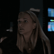 a woman in a dark room looks at something