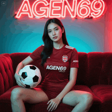 a woman sitting on a couch holding a soccer ball in front of a neon sign that says agen 69