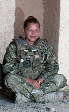 a woman in a military uniform has a patch on her chest that says " isaf "