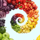 a rainbow of fruits and vegetables are arranged in a spiral on a white background .