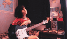 a girl is playing a guitar in front of a clock that says 8:51