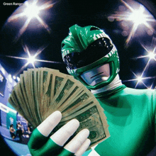 a green ranger is holding a bunch of money in his hands