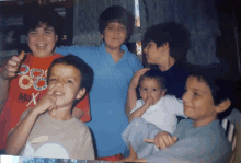 a group of children are posing for a photo and one of them is wearing a shirt that says max