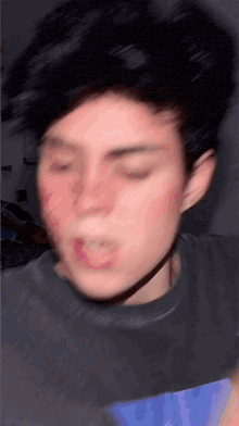 a close up of a person 's face with their eyes closed and their hair blowing in the wind .