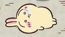 a cartoon rabbit is laying on the ground with a bubble on its head